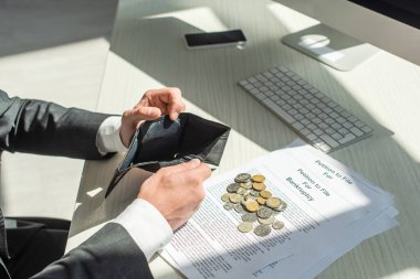 Bozuk paraların ve iflas dilekçelerinin yanında boş cüzdan tutan işadamı manzarası