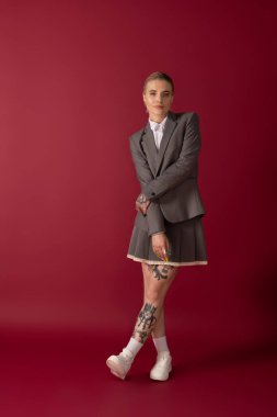 Bir bacağı çapraz duran genç bir kadın modern zarafet ve stili somutlaştırıyor..