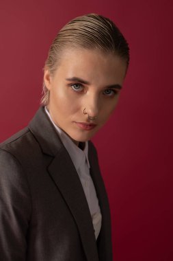 Şık bir genç kadın kendine güvenerek poz verir, çarpıcı bir ortamda zarafet saçar..