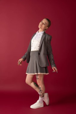 Büyüleyici kadın model zarif bir kıyafet ve benzersiz dövmeleriyle moda anlayışını sergiliyor..