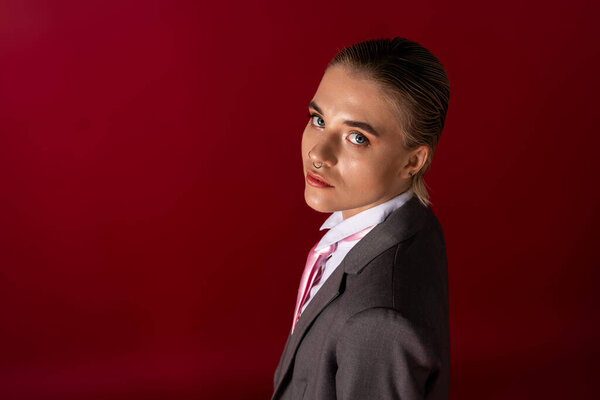 A young beautiful woman in a sophisticated suit, exuding confidence with a striking look.