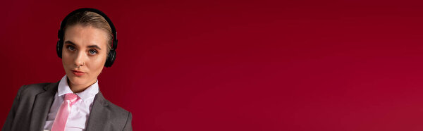 Стильная молодая женщина в модном костюме и наушниках источает уверенность.