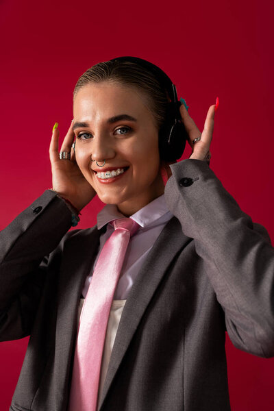 Radiating joy, the fashionable young woman engages with her headphones and colorful style.