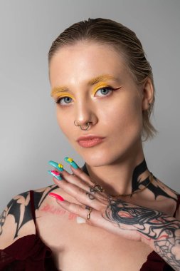 Güzel genç bir kadın kendine güvenerek poz veriyor, eşsiz stilini ve renkli tırnaklarını sergiliyor..