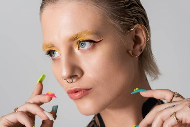 Cesur makyajlı ve aksesuarlı şık bir genç kadın kendine güven ve moda yayar..