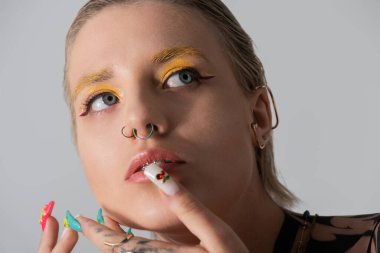 Benzersiz aksesuarları ve canlı makyajı olan zarif genç bir kadın yaratıcı kişiliğini ifade ediyor..