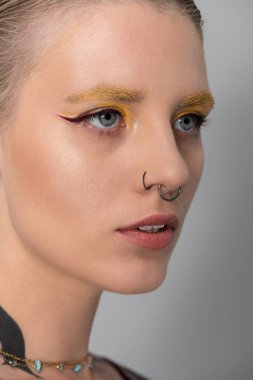 Göz alıcı makyajı ve şık bir görünüşü olan güzel bir genç kadın dikkat çekiyor..