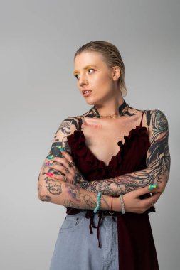 Tarz sahibi genç bir kadın modern bir ortamda benzersiz dövmelerini ve modasını sergiliyor..