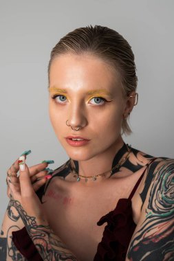 Çarpıcı stili ve dövmeleri olan kendine güvenen genç bir kadın dikkatleri hiç zorlanmadan çekiyor..