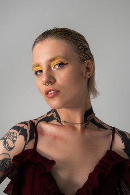 Büyüleyici genç bir kadın benzersiz tarzını ve cesur makyajını sergiliyor, kendine güveni ve cazibesi yayılıyor..