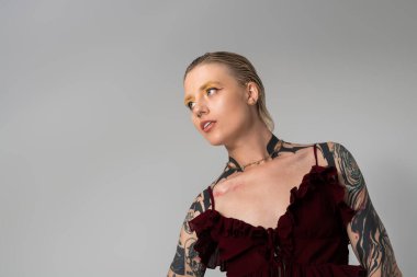 Güzel genç bir kadın kendine güveni ve tarzıyla çarpıcı dövmeleri ve canlı makyajı var.