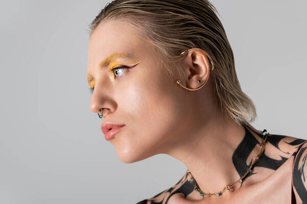 Charming young woman with striking features poses gracefully, highlighting her fashion and style.