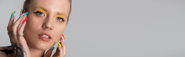 Beautiful woman showcases her trendy style through colorful makeup and expressive accessories.