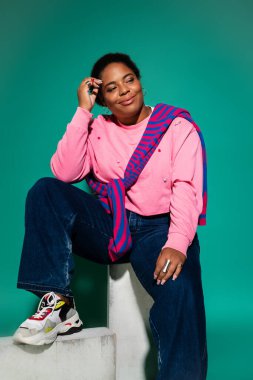 Büyük boy Afro-Amerikan kadın şık bir sonbahar elbisesi içinde parlıyor..