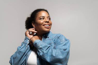 Kendine güveni tam ve cüsseli bir kadın modaya uygun bir sonbahar elbisesi içinde stüdyoda poz vermekten zevk alır..