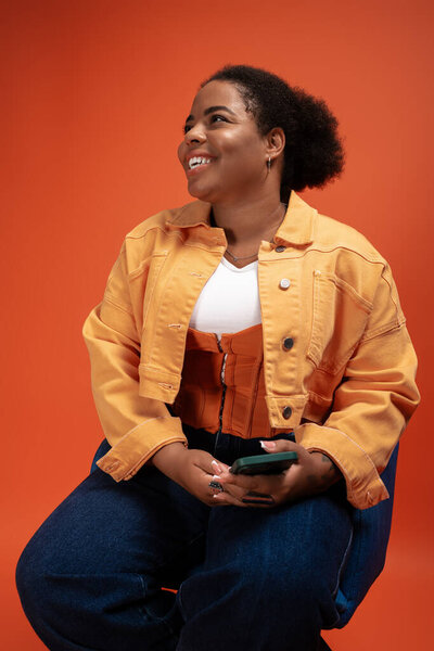 Африканская женщина plus size демонстрирует свой триумфальный осенний наряд в оживленной студии.