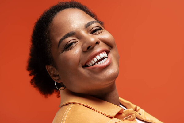 A plus size African American woman enjoys a fun moment in her fashionable autumn outfit.