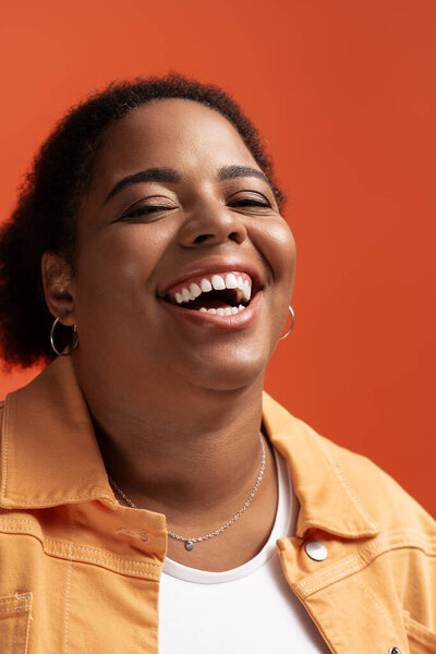 Стильная афроамериканка плюс размер ярко улыбается в модном осеннем наряде.