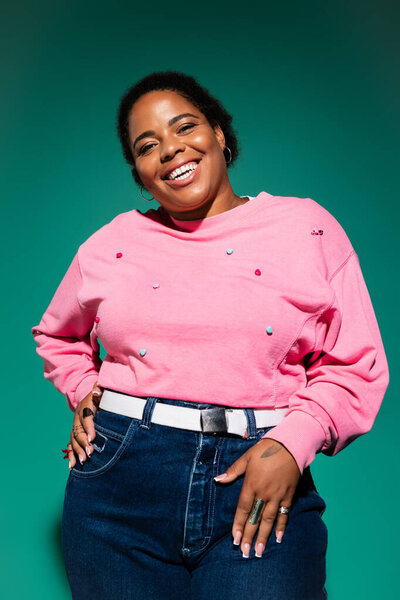 A confident plus size woman poses in a vivid autumn outfit, full of personality and style.