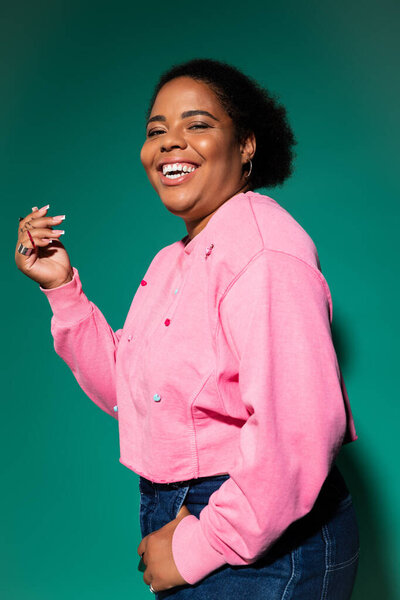 Женщина празднует положительную реакцию на тело в ярком осеннем наряде, излучающем стиль и уверенность.