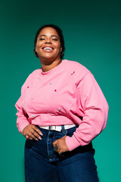 Уверенная в себе женщина plus size позирует в триумфальном осеннем наряде, излучая стиль и радость.