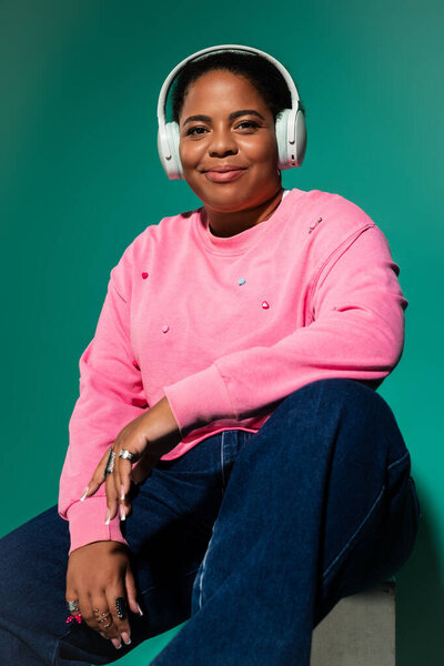 Уверенная в себе чернокожая женщина plus-size демонстрирует свой стиль в ярком осеннем наряде.