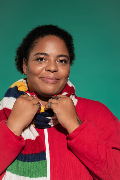 A confident plus size woman poses in a trendy autumn outfit, radiating style and positivity.