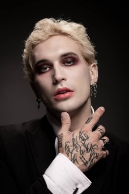 Genç, yakışıklı bir adam çarpıcı bir Cadılar Bayramı kostümü ile gösteriş yapıyor..