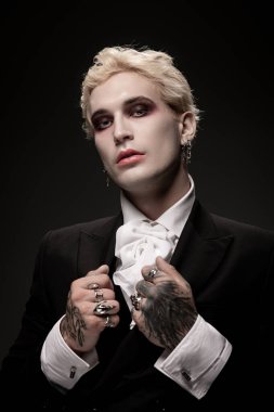 Genç ve yakışıklı bir adam özenli Cadılar Bayramı kostümü ve tarzıyla hava atıyor..