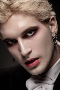 Göz kamaştırıcı Cadılar Bayramı kostümü içindeki genç bir adam makyaj ve saç stiliyle gözlerini kamaştırıyor..