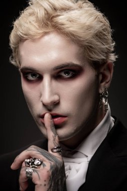 Yakışıklı genç adam, süslü Cadılar Bayramı kostümü içinde büyüleyici ve gizemli bir görünüş sergiliyor..