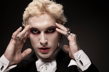 Çarpıcı bir kostüm ve kalın makyajlı genç bir adam bu Cadılar Bayramı 'nda kendinden emin bir şekilde parlıyor..