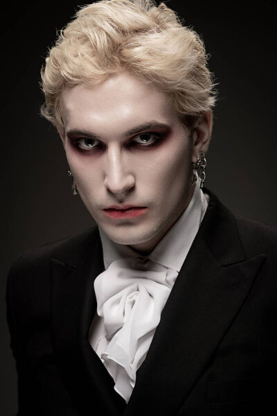 A young man showcases a stunning Halloween costume that highlights his striking features and makeup.