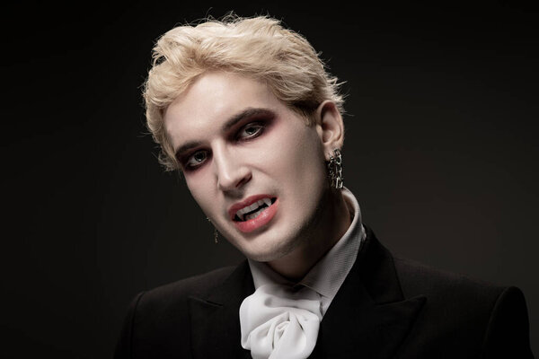 Красивый молодой человек в костюме на Хэллоуин привлекает внимание своим макияжем и стилем