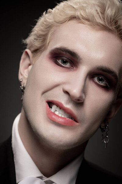 Молодой человек демонстрирует впечатляющий костюм на Хэллоуин с смелым макияжем, представляя захватывающий вид.