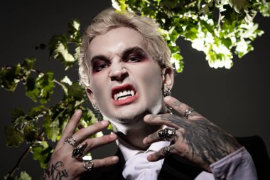 Çarpıcı bir Cadılar Bayramı kostümü giymiş genç bir adam sinirli stilini ve neşeli ruhunu sergiliyor..