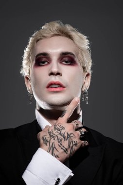 Genç ve yakışıklı bir adam dramatik bir Cadılar Bayramı kostümü içinde yaratıcılığını sergiliyor..