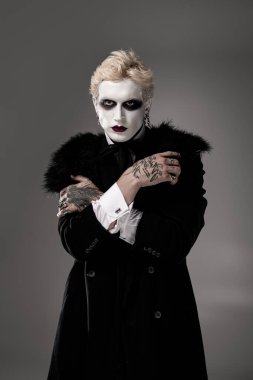 Genç ve yakışıklı bir adam Cadılar Bayramı destansı kılığını makyaj ve kostüm detaylarıyla gösterir..