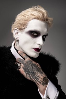 Genç ve yakışıklı bir adam etkileyici bir Cadılar Bayramı kostümü sunar..