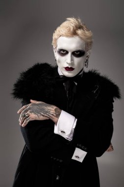 Yakışıklı genç bir adam destansı bir Cadılar Bayramı kostümü sergiliyor..