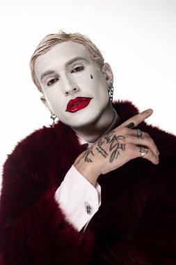 Yaratıcı Joker kostümlü genç bir adam Cadılar Bayramı şenliklerinde güven içinde poz veriyor..