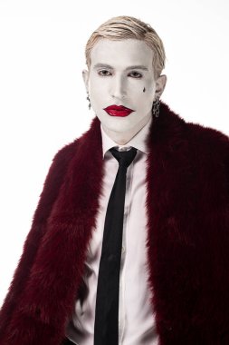 Genç bir adam destansı Joker kostümünü cesur makyajı ve Cadılar Bayramı için dramatik kıyafetleriyle sergiliyor..