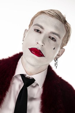 Genç bir adam büyüleyici Joker kostümünü sergiliyor, Cadılar Bayramı 'nı tarzıyla kutlamaya hazır..