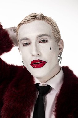 Genç adam dramatik makyajlı Joker kostümü giyiyor, Cadılar Bayramı için ideal..