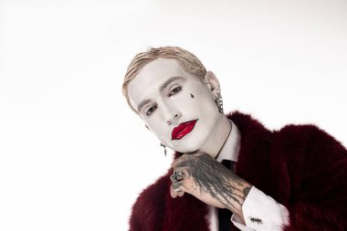 Genç ve yakışıklı bir adam etkileyici Joker kostümünü Cadılar Bayramı kutlamalarında sergiliyor..