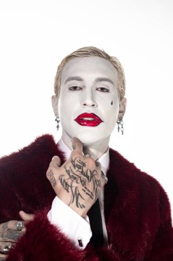 Yakışıklı genç adam cesur makyajlı Joker gibi giyinerek Cadılar Bayramı yaratıcılığını sergiliyor..