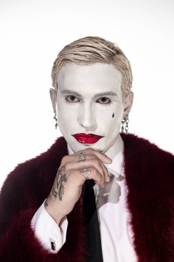 Genç adam Cadılar Bayramı için kendine güvenen bir Joker kostümü giyiyor..