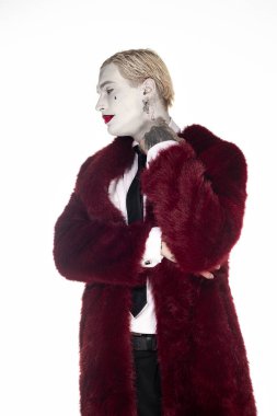 Joker gibi giyinmiş genç bir adam kendine güveni tam, çarpıcı bir kostümü ve canlı bir makyajı var..