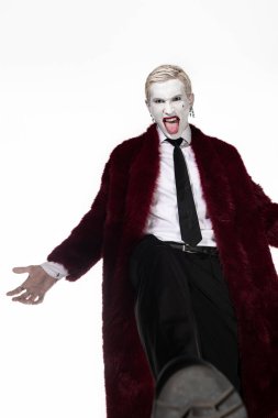 Genç bir adam etkileyici bir Joker kostümü sergiliyor, Cadılar Bayramı kutlamaları için heyecan saçıyor..