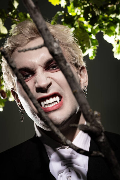A young handsome man displays an impressive Halloween costume with fierce features under soft light.
